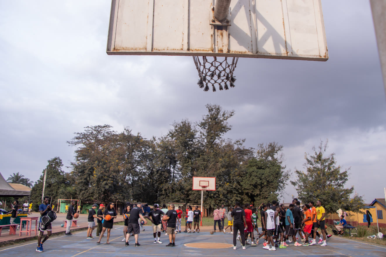 Athletes, coaches and Take Em Home partners gathered on a basketball court in Ghana