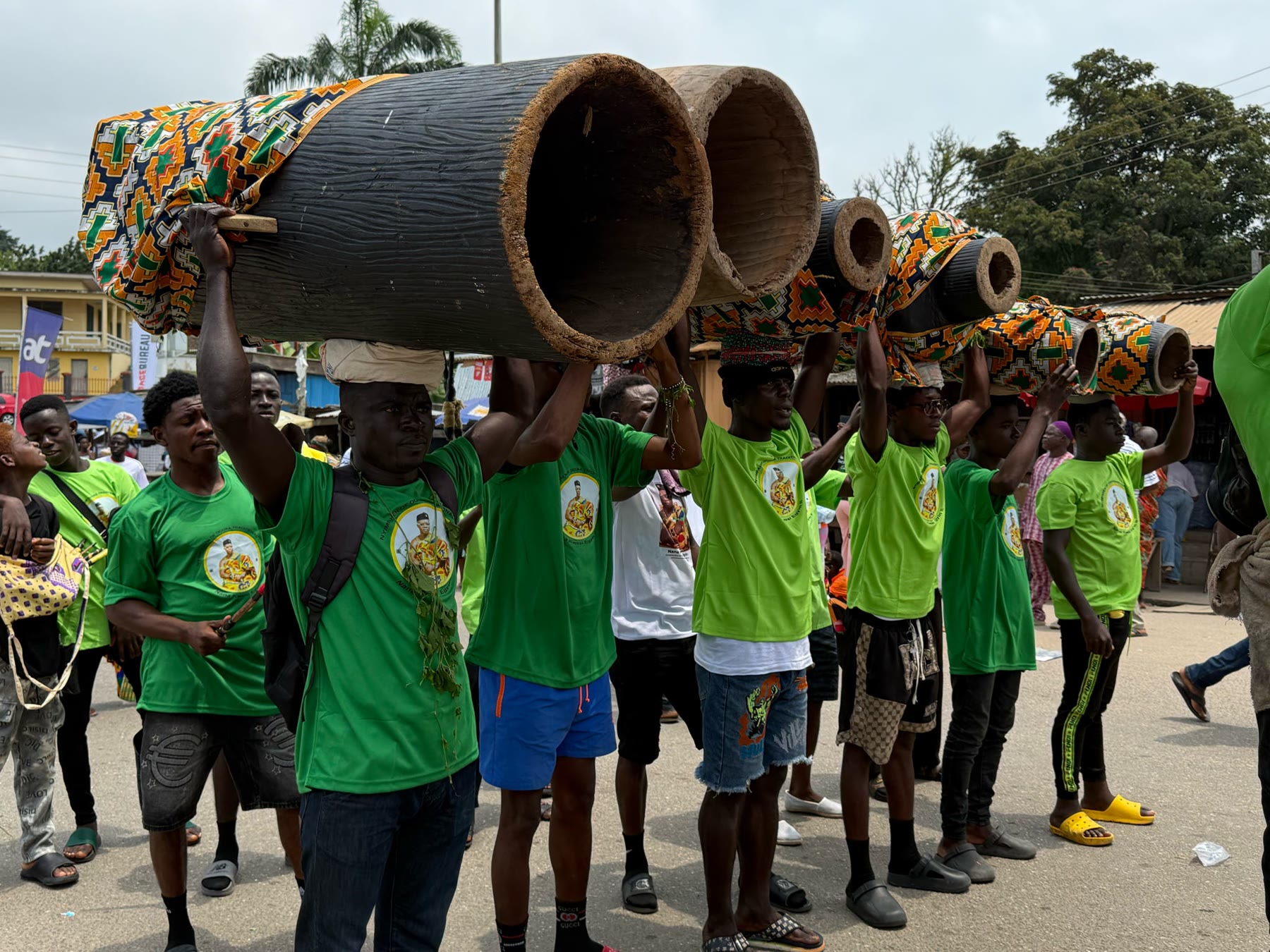 Young drummers carrying traditional drums during a procession in Ghana
