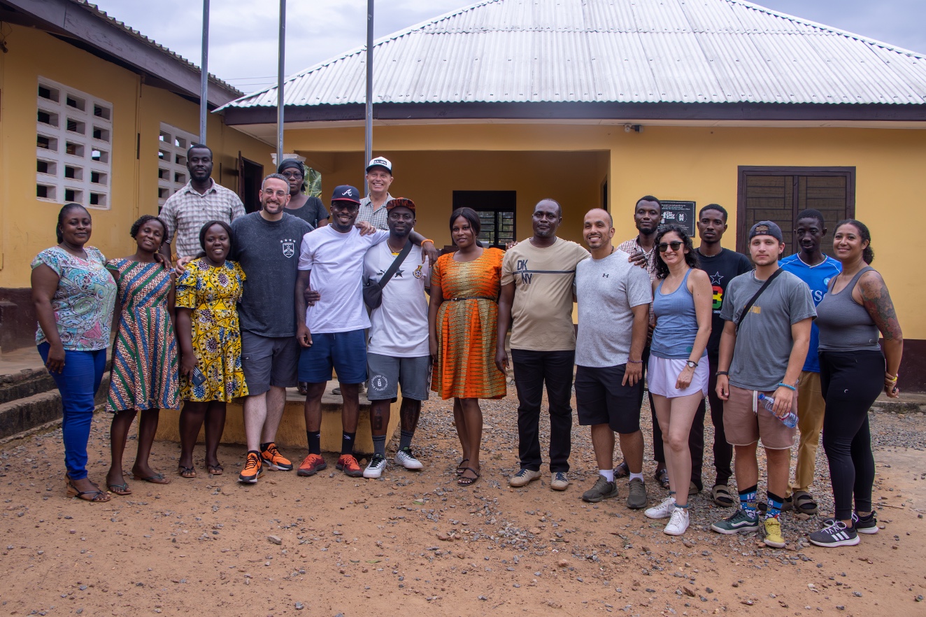 Kellen with a diverse group of Take Em Home travelers and community partners in Ghana
